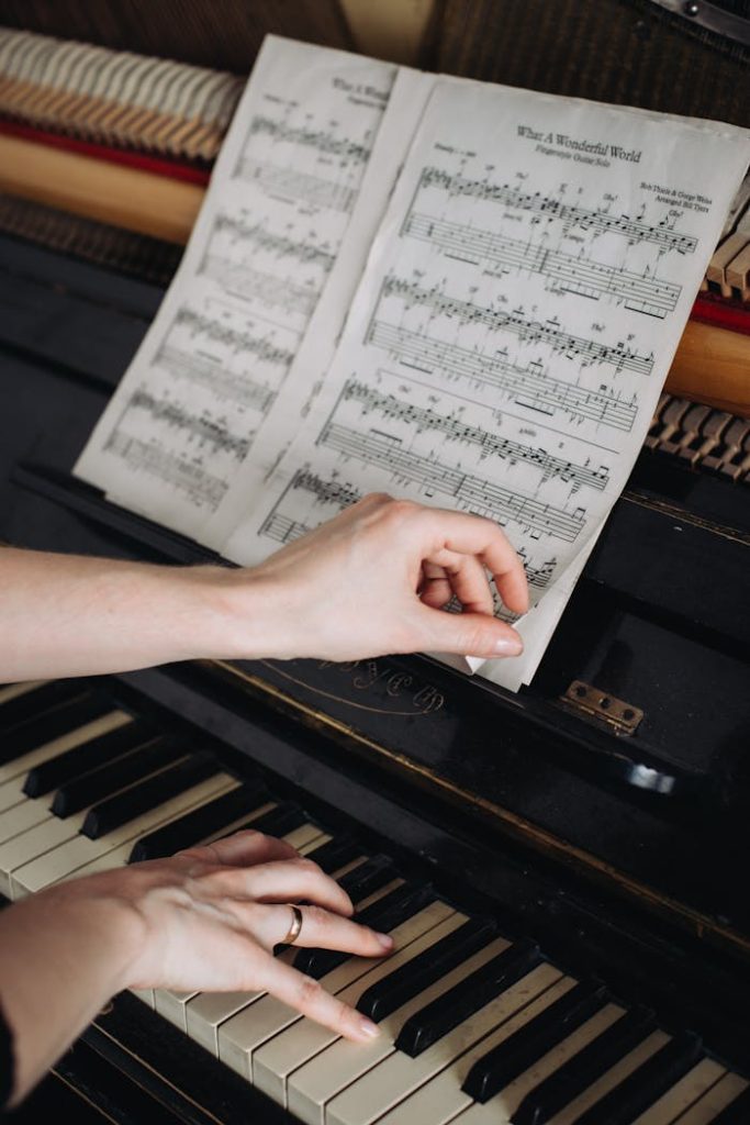 Close-up of a womans hands on a piano, turning sheet music pages, capturing musical focus.