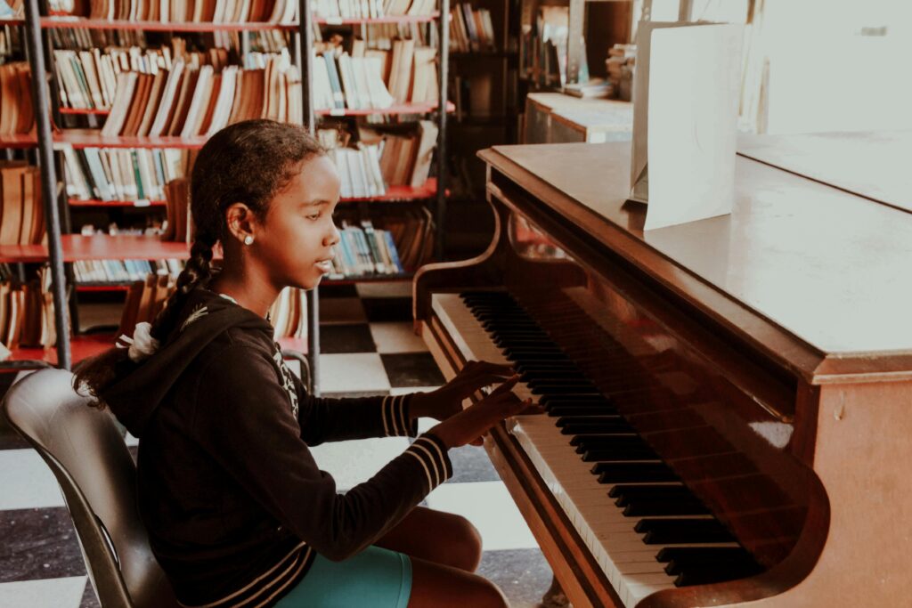 A young girl plays piano in a library, showcasing a blend of music and education.
